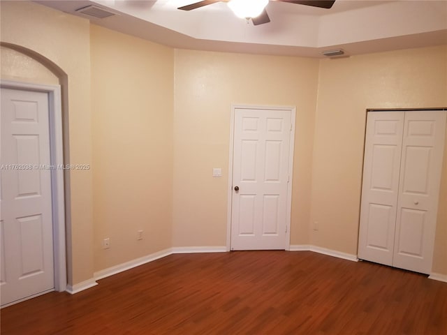 unfurnished bedroom with dark wood finished floors, baseboards, and visible vents