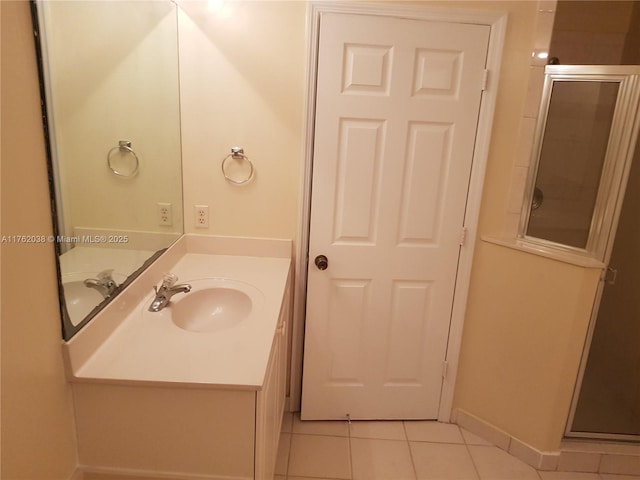 full bath with baseboards, vanity, a shower stall, and tile patterned flooring