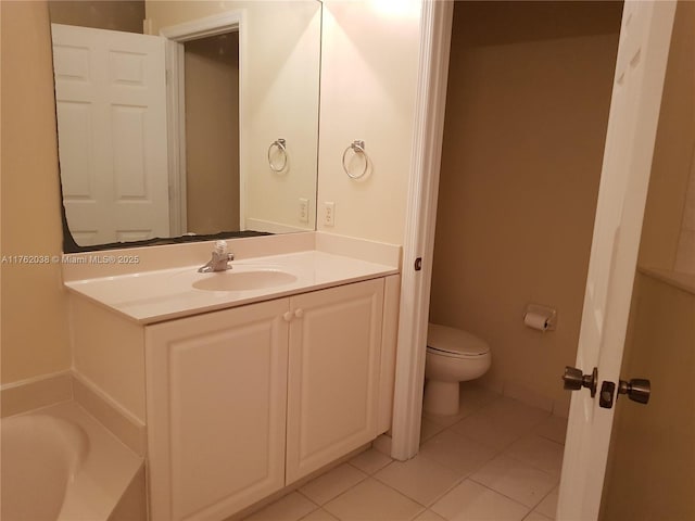 bathroom featuring tile patterned flooring, toilet, vanity, and a bath