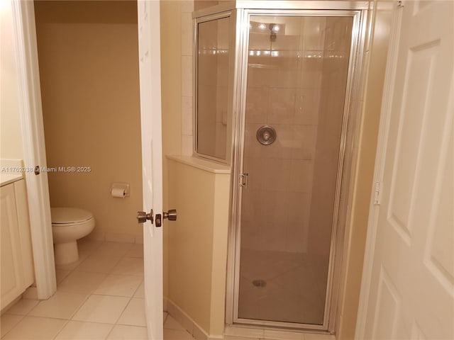 full bathroom with tile patterned flooring, a stall shower, toilet, and baseboards