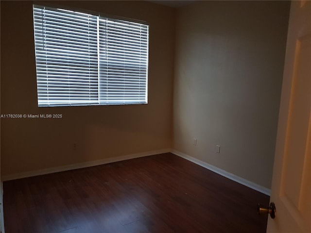 unfurnished room featuring baseboards and wood finished floors