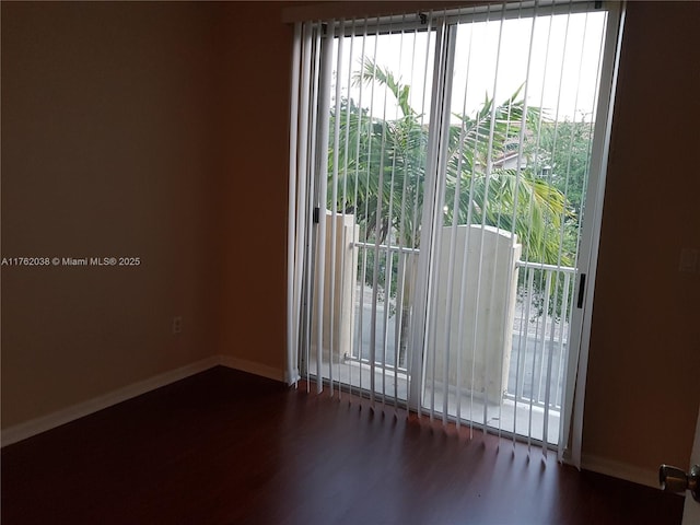 unfurnished room with baseboards and wood finished floors