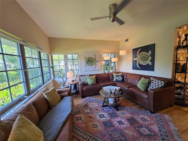 living room featuring visible vents, a ceiling fan, lofted ceiling, and wood finished floors