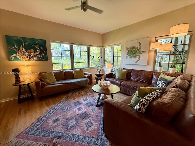 living room featuring wood finished floors, baseboards, and ceiling fan