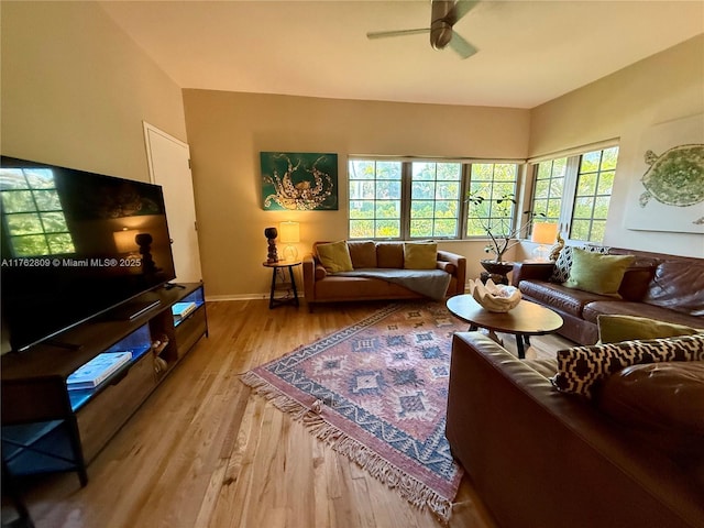 living room featuring a ceiling fan, light wood-style floors, and baseboards