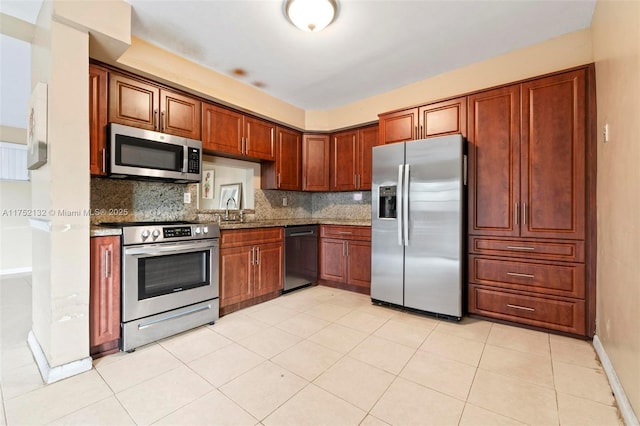 kitchen featuring light tile patterned floors, backsplash, stainless steel appliances, and baseboards