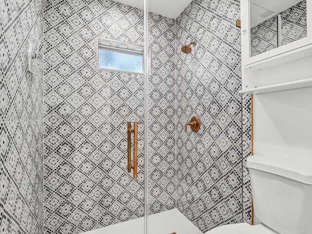 full bathroom featuring toilet and a tile shower