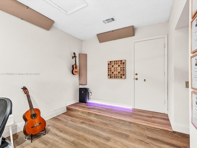 interior space with visible vents, baseboards, and wood finished floors