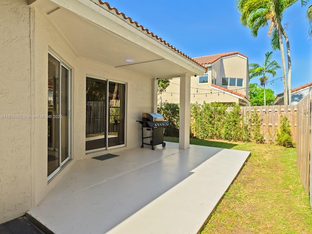 view of patio with a grill and fence