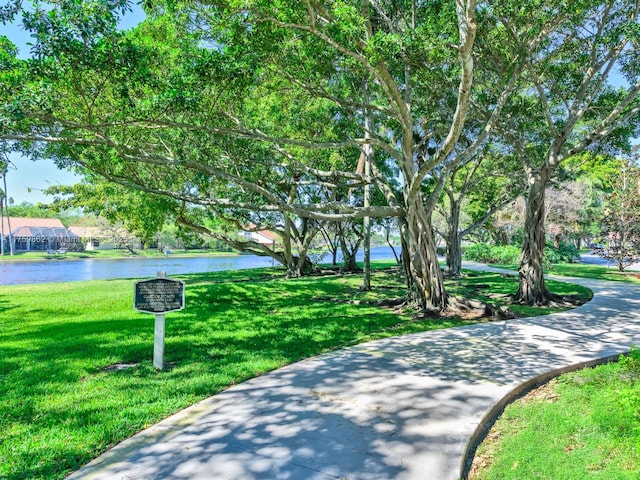 view of community with a lawn and a water view