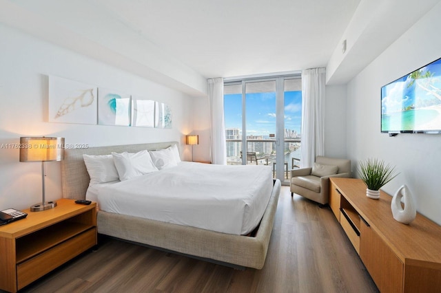 bedroom with wood finished floors, floor to ceiling windows, and access to outside