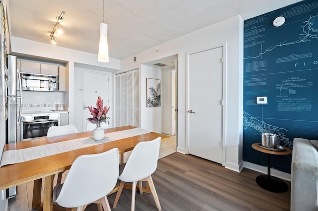 dining area with baseboards and dark wood-style flooring