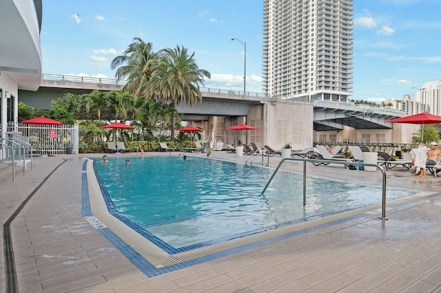 community pool with a patio and fence