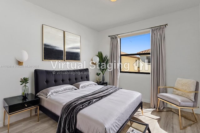 bedroom with baseboards and wood finished floors