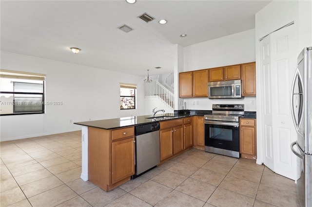 kitchen with visible vents, dark countertops, a sink, light tile patterned floors, and stainless steel appliances
