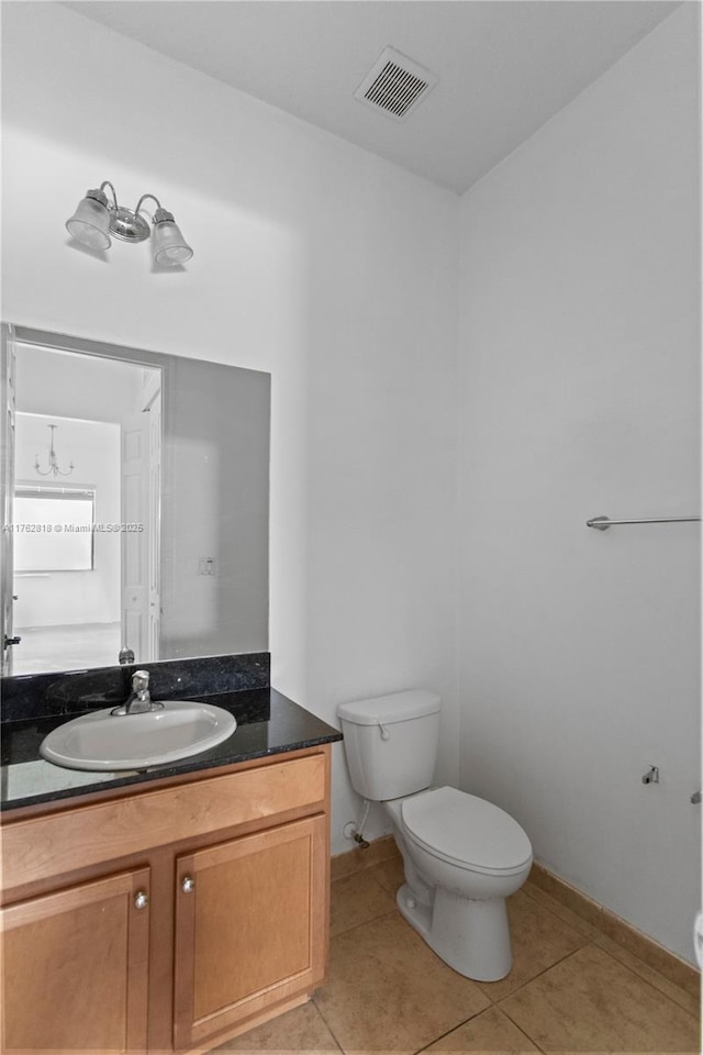 bathroom featuring visible vents, vanity, toilet, baseboards, and tile patterned floors