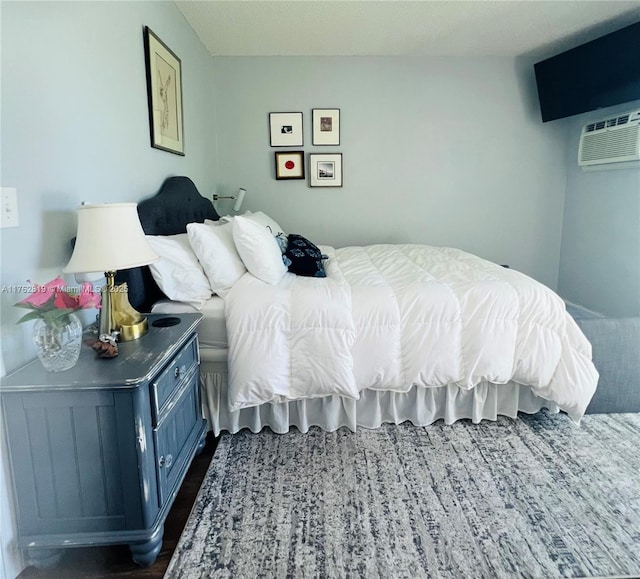 bedroom with dark wood-style flooring and a wall mounted air conditioner