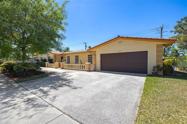 view of front of property with stucco siding, a garage, driveway, and a tiled roof