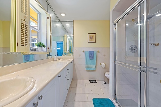 full bath featuring a shower stall, tile walls, toilet, and a sink