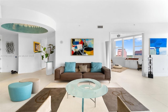 tiled living room featuring visible vents and baseboards