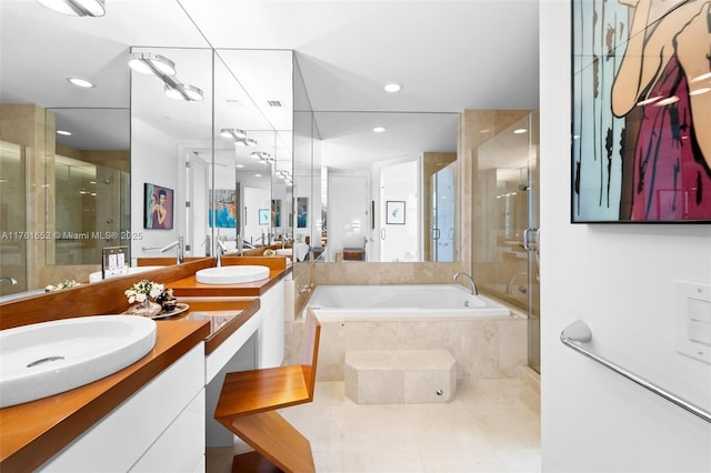 bathroom featuring a sink, a garden tub, a stall shower, and double vanity