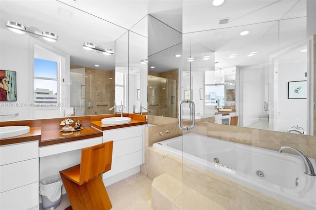 bathroom featuring a shower stall, double vanity, a whirlpool tub, and a sink