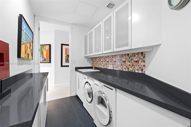 washroom with visible vents, cabinet space, a sink, dark tile patterned floors, and independent washer and dryer