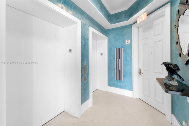 hallway with wallpapered walls, light tile patterned floors, and baseboards