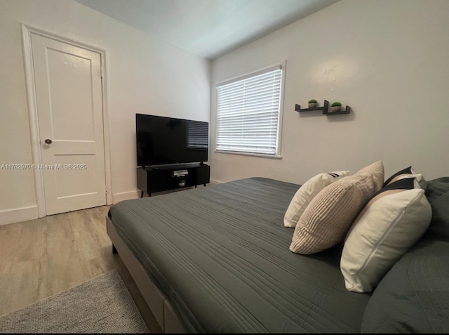 bedroom with baseboards and wood finished floors