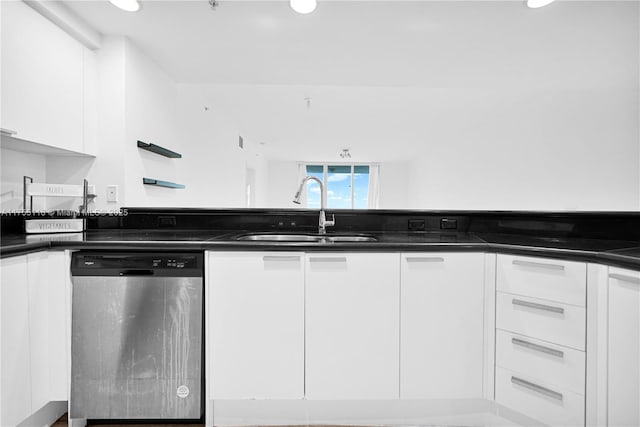 kitchen featuring a sink, dark countertops, dishwasher, and white cabinetry