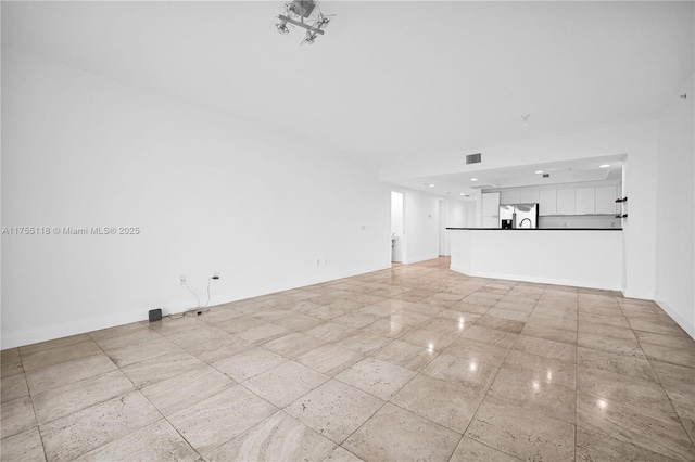 unfurnished living room featuring visible vents and baseboards