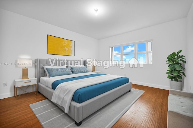 bedroom with wood finished floors and baseboards