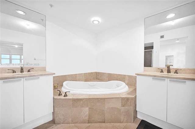 bathroom featuring visible vents, two vanities, and a sink