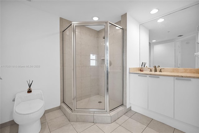 bathroom featuring tile patterned floors, a shower stall, toilet, and vanity