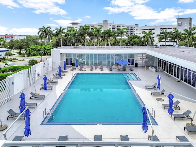 community pool with a patio area and fence