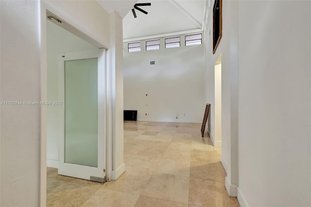 corridor featuring visible vents and a high ceiling