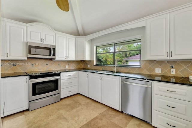 kitchen featuring white cabinetry, lofted ceiling, appliances with stainless steel finishes, and a sink