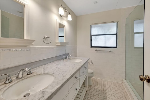 full bathroom with tile patterned flooring, tile walls, toilet, and a sink