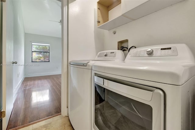 laundry room featuring washer and clothes dryer, laundry area, light wood-style flooring, and baseboards