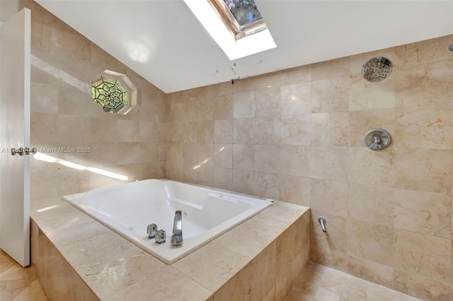 bathroom with vaulted ceiling with skylight, tile walls, a bath, and a tile shower