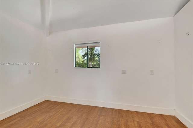 unfurnished room featuring baseboards and light wood finished floors