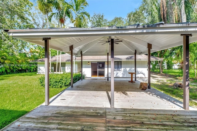 deck with a ceiling fan and a lawn