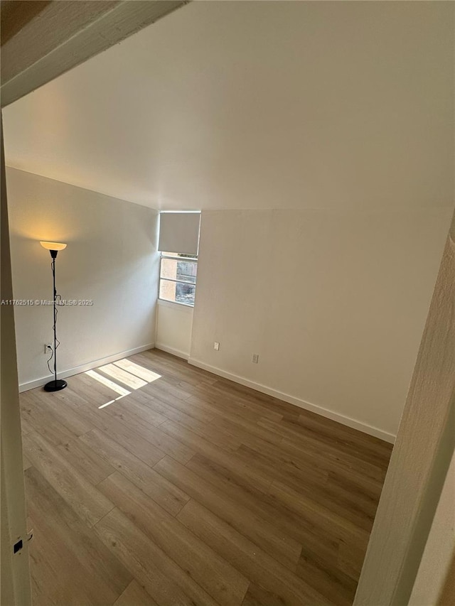 unfurnished room with wood finished floors and baseboards