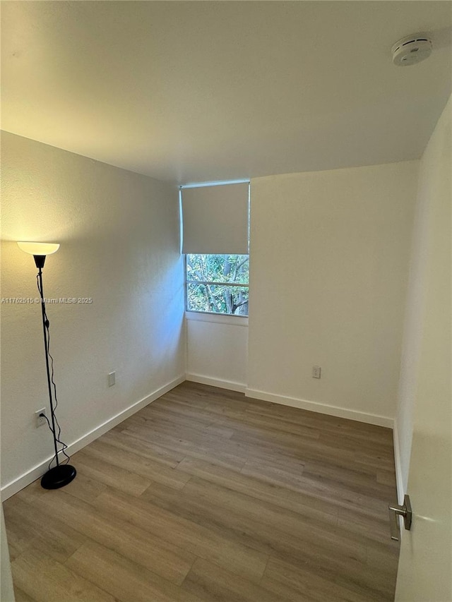 unfurnished room with wood finished floors and baseboards