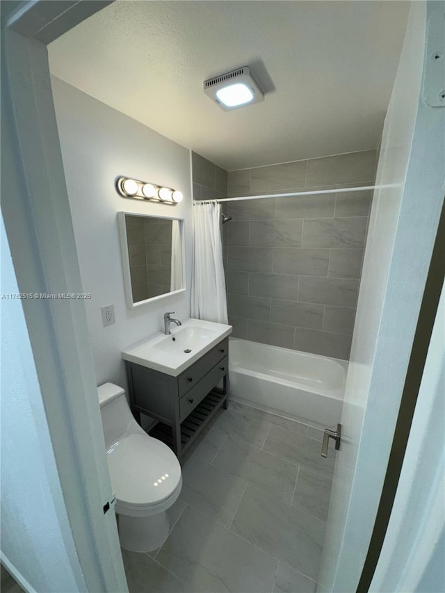 bathroom with toilet, vanity, and shower / tub combo