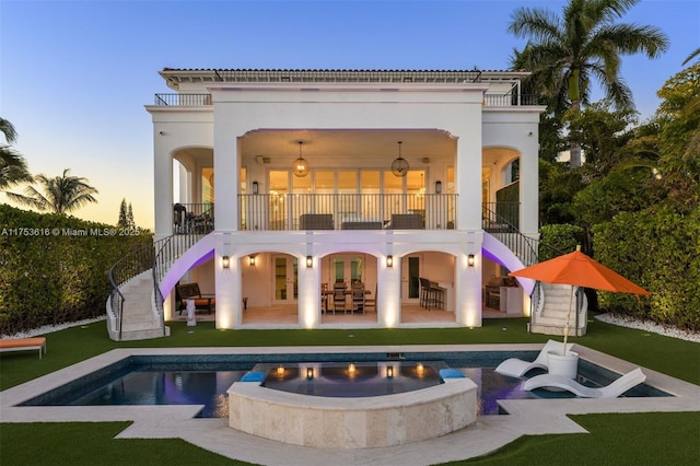 back of house featuring a patio area, stucco siding, a lawn, and stairs