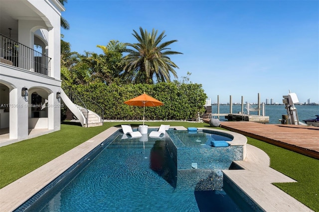 outdoor pool featuring a jacuzzi, a lawn, a dock, and stairway