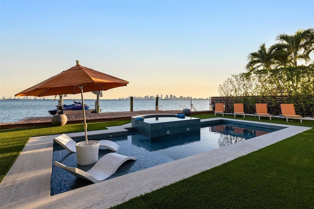 view of swimming pool featuring a yard, a water view, a boat dock, and a pool with connected hot tub