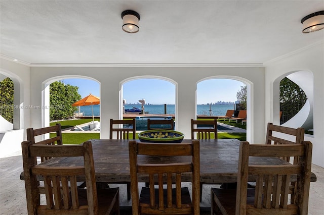 dining area with a water view and ornamental molding