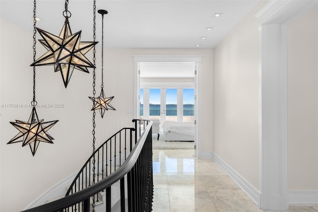 corridor featuring baseboards, recessed lighting, a water view, an upstairs landing, and marble finish floor